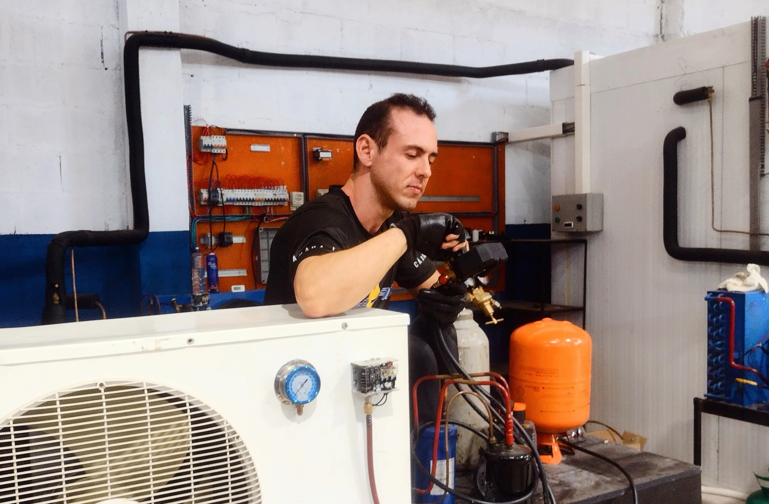Técnico realizando diagnóstico e regulagem em equipamento de refrigeração comercial